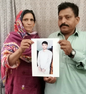 Parents of Noman Masih hold a photograph of their imprisoned son. 