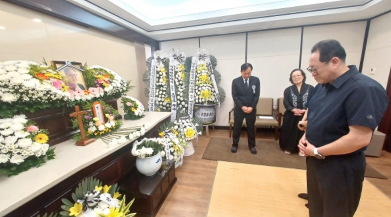 A mourner pays his respects at Pastor Jonah Lee’s funeral. 