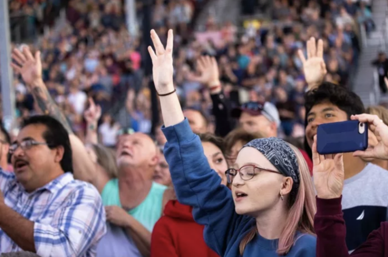 Attendees raise their hands in worship during Franklin Graham's Route 66 