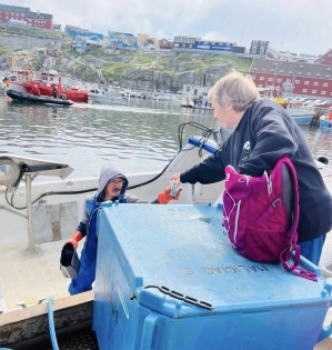 Handing coffee to a local fisherman