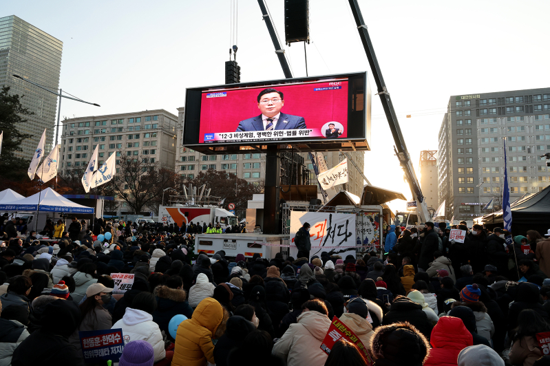 Protesters watch televised coverage as the parliament votes to impeach South Korean president Yoon Suk Yeol